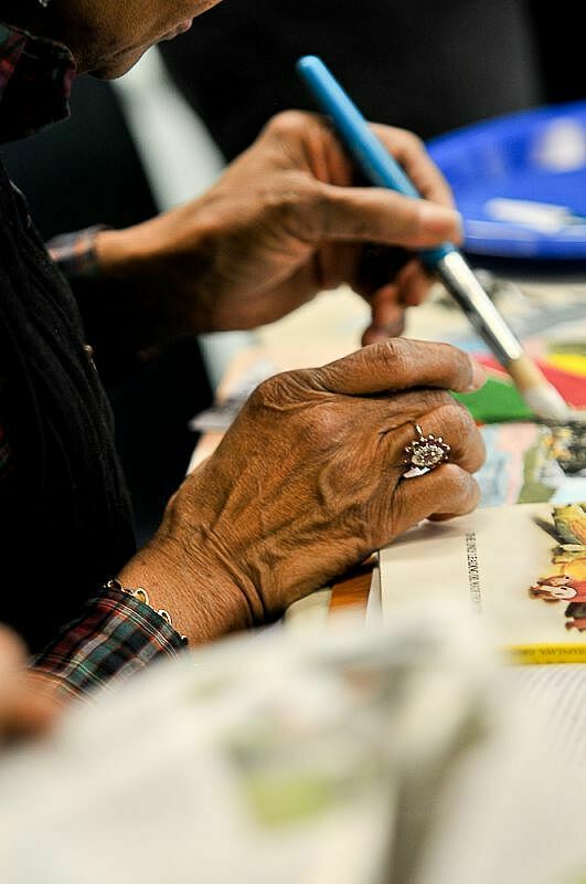 Woman holds paint brush working.