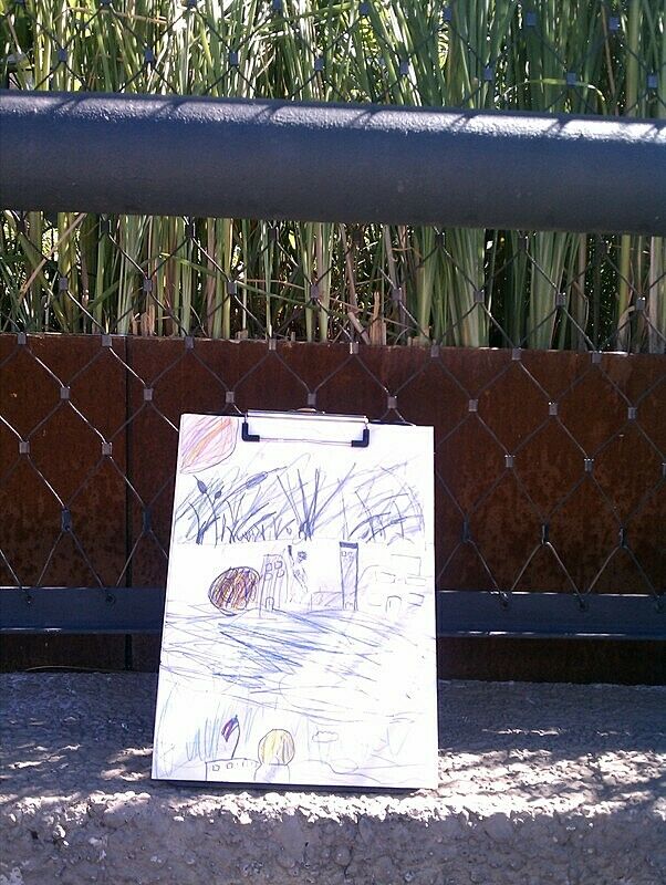 Child's drawing of a sitting against a fence.