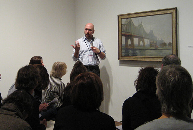 A teacher presents a painting by Edward Hopper to an art class.