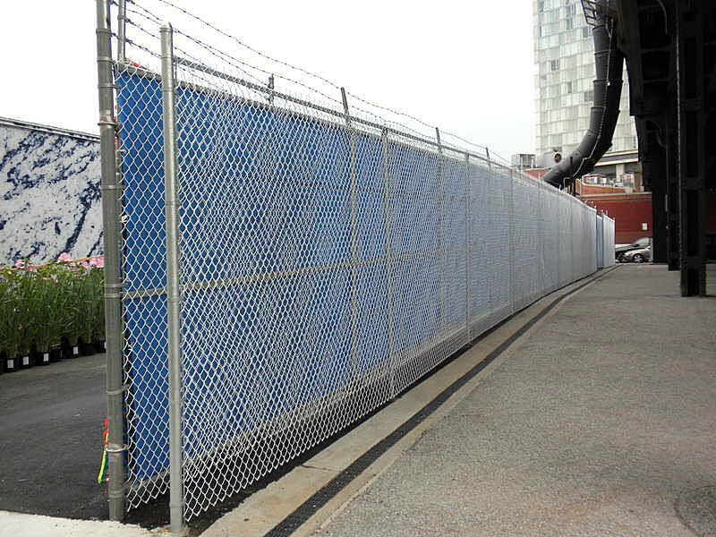 A chain link fence covered in blue material