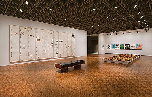 Gallery view of a bench with artwork on surrounding walls.