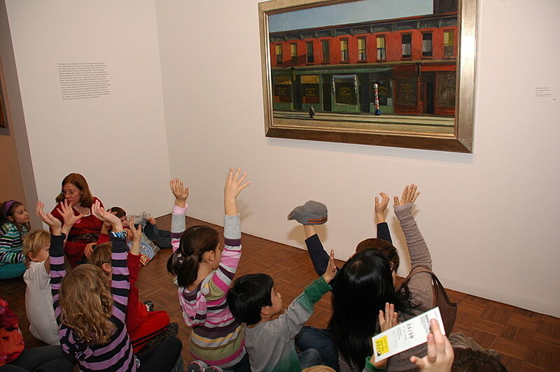 Kids raise their hands in front of an Edward Hopper. 