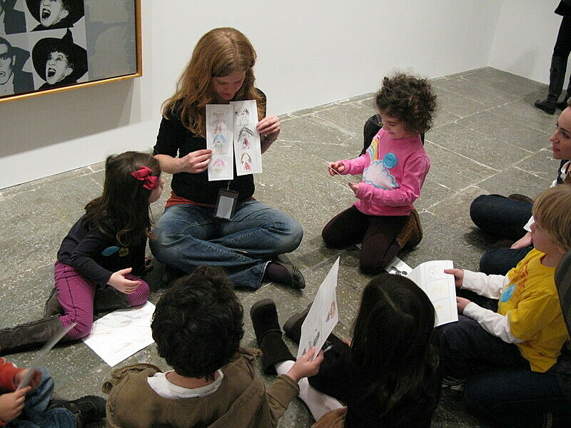 Kids show off their art to a teacher