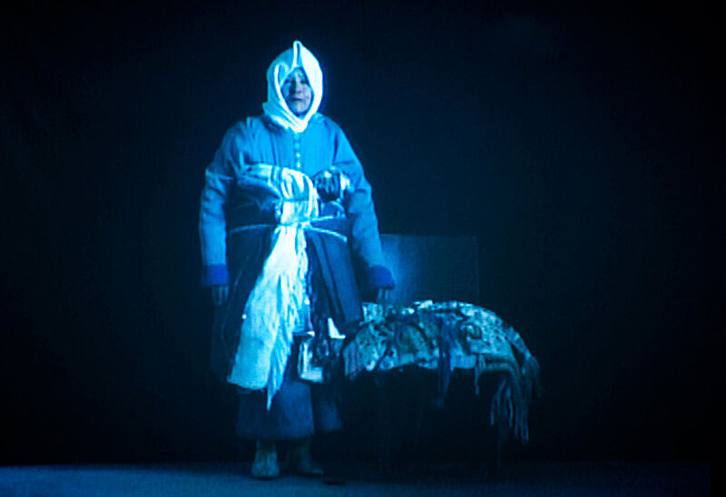 Person walking with layers of clothes on in a blue light.