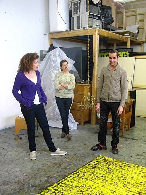 Two teachers talking to artist Angel Otero