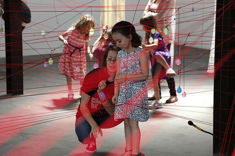 Families play with string during an interactive project.