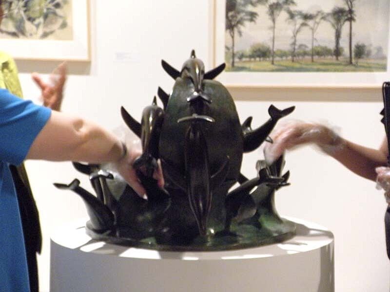 Blind visitors touching a sculpture