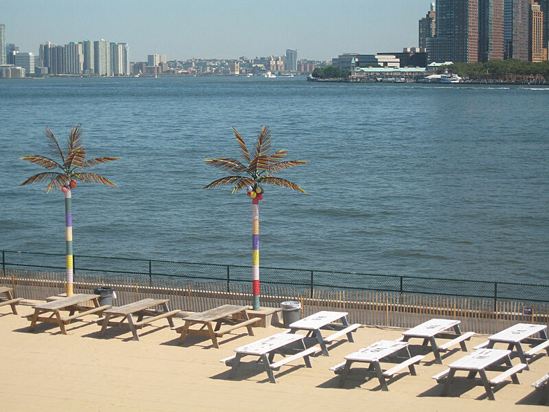 Picnic tables lined up on the shore of Governor's Island.