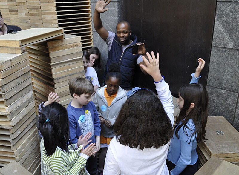 The artist surrounded by kids in his installation