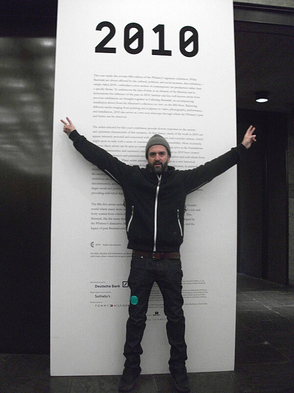 The artist poses in front of his work