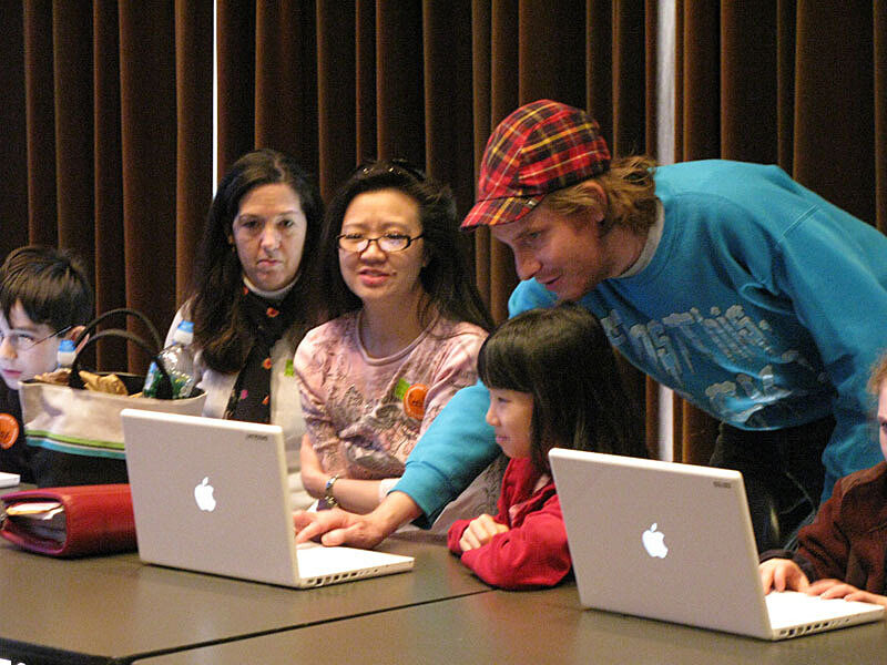 The artist works with a family on a computer
