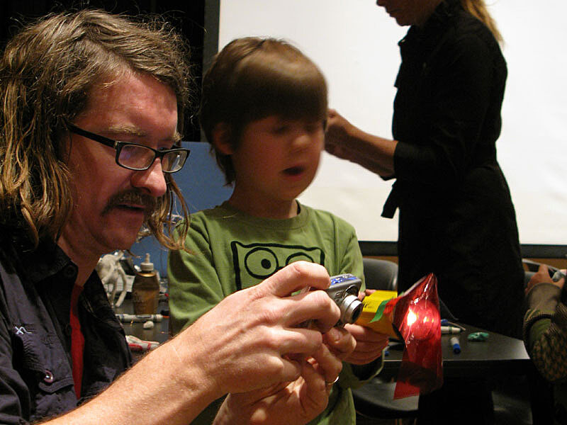 The artist shows his work to a child