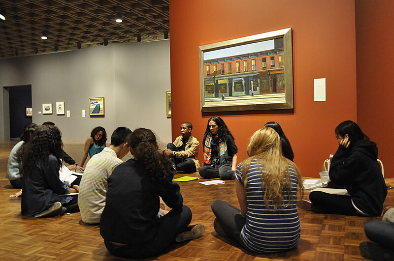 Students sit on the gallery floor to talk about art from the museum collection.