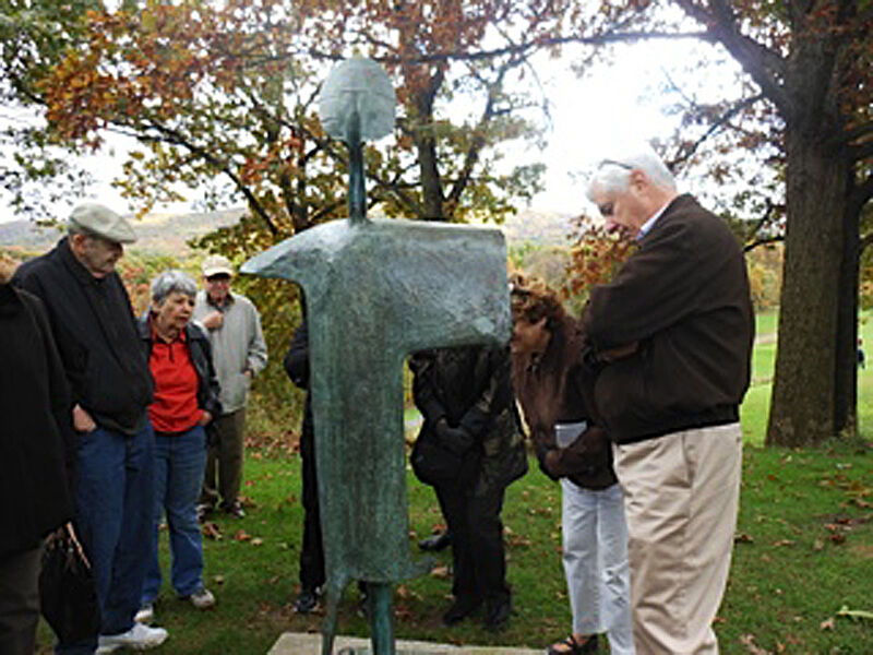 A metal sculpture surrounded by people.