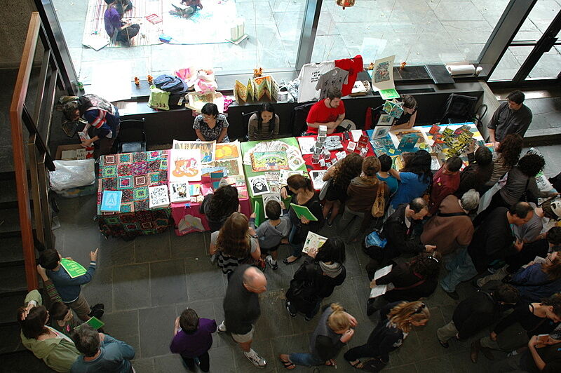 A crowd gathers in the lobby of the museum for a comic event.