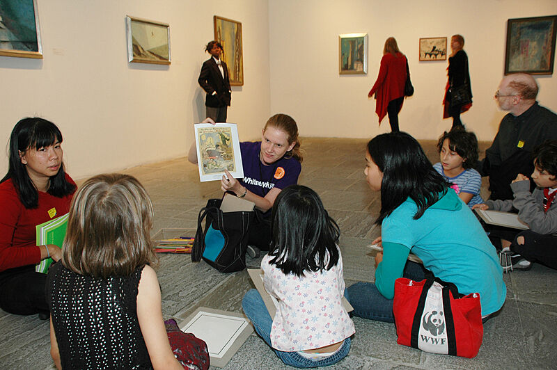 A staff member shows off an artwork in the gallery.