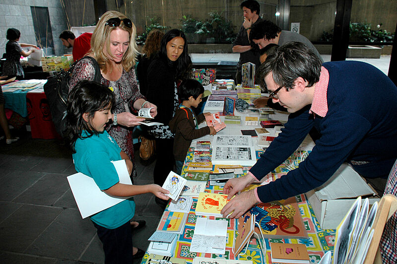 A family browses a table of comic books.