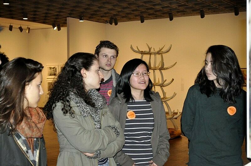 students standing in room of artwork