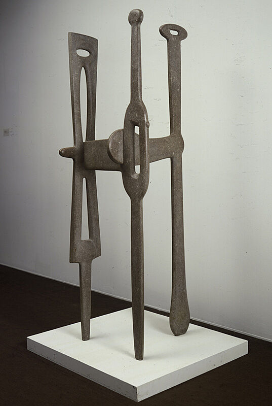A marble sculpture of three long poles connected to each other.