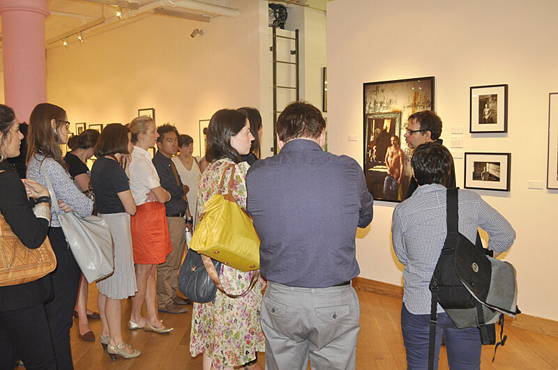 Gallery goers listen to tour guide at museum.