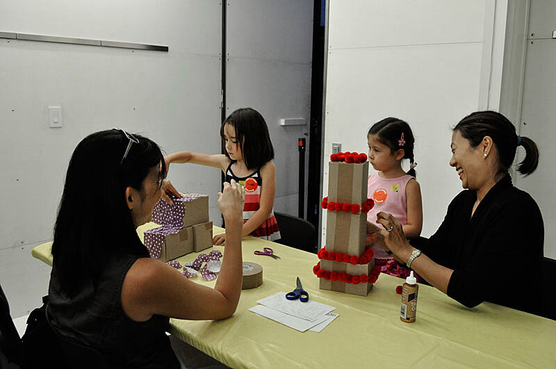 Mothers and daughters work on a sculpture project together.