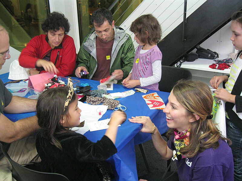 Families collaborate together on an art project.