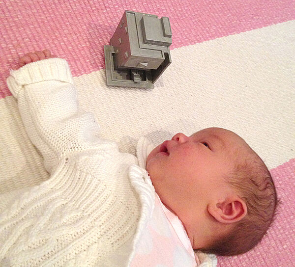 A baby next to a model of the Whitney Museum
