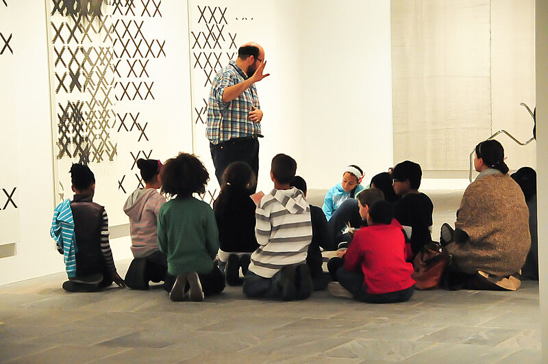 Children in a gallery listening to a teacher