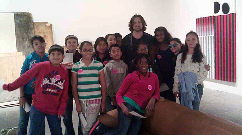 A class poses with the artist 
