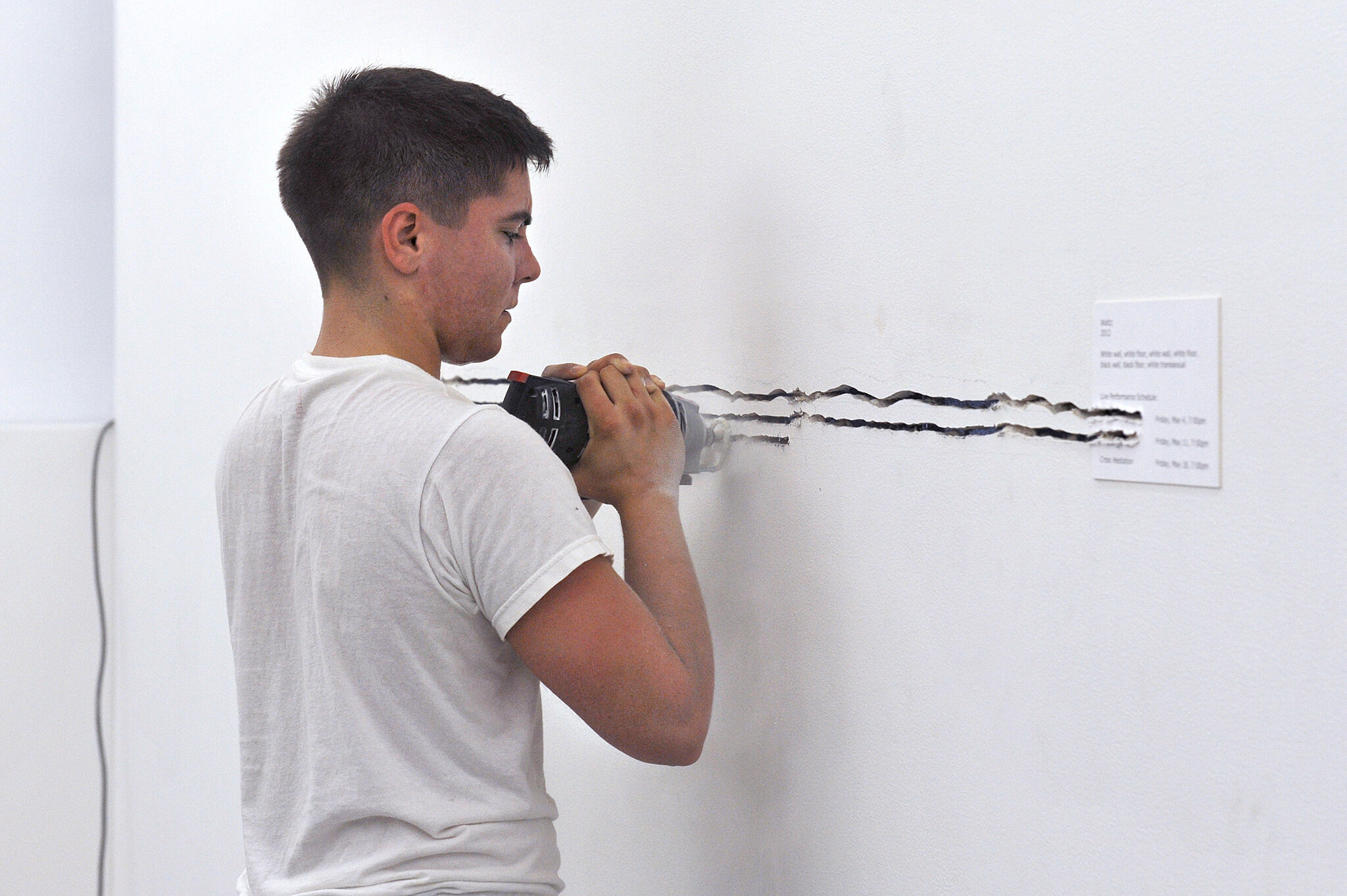 Person punctures wall with staple gun.