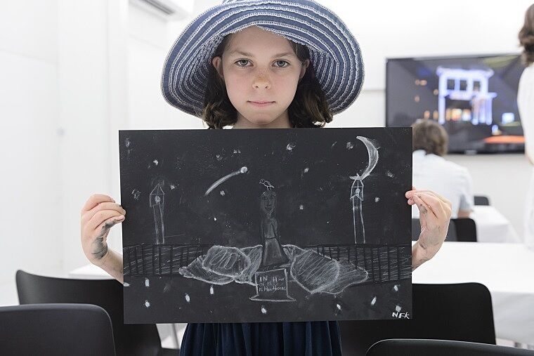 A child poses with her art