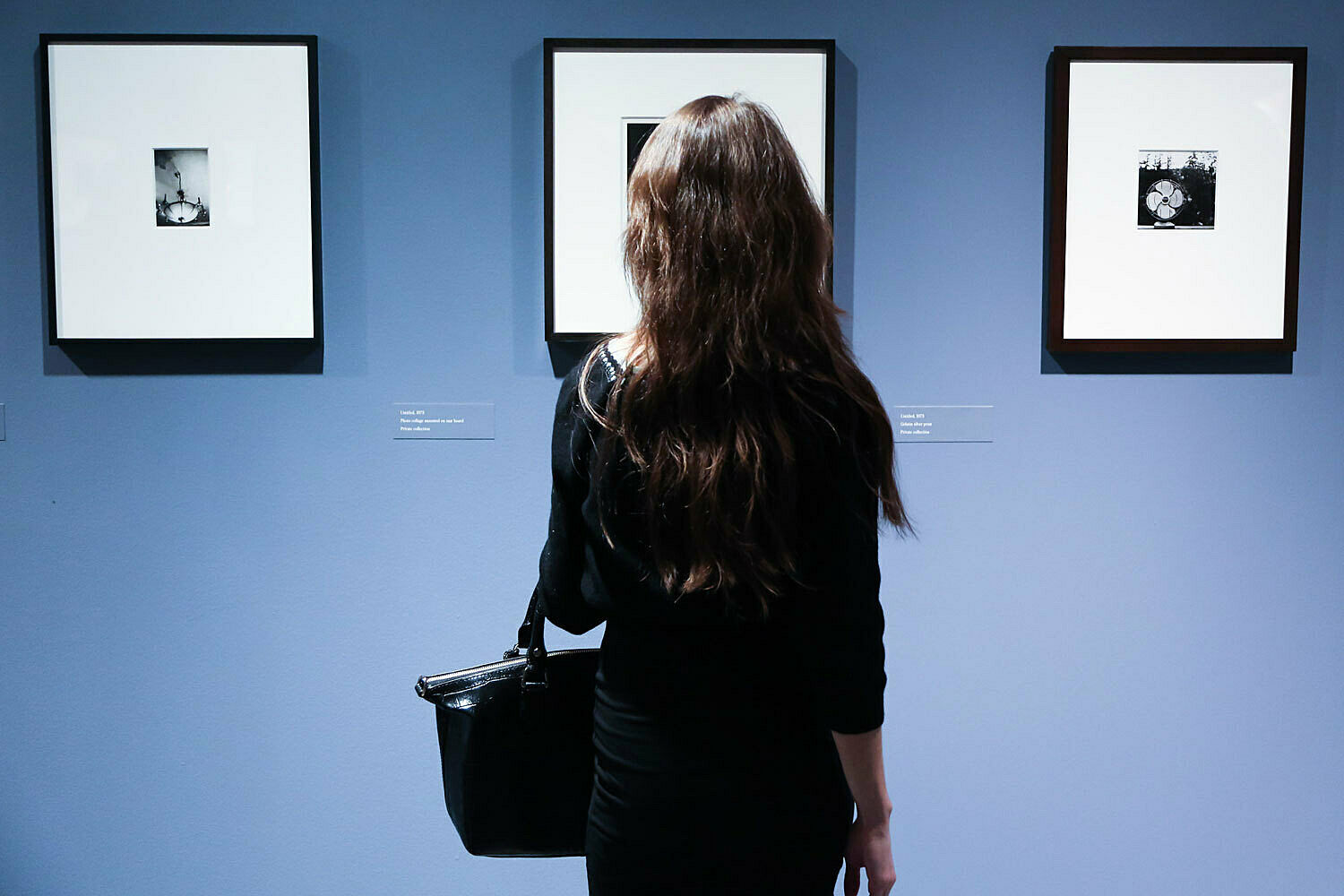 woman looking at three photographs