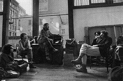 three men sitting in an artist studio