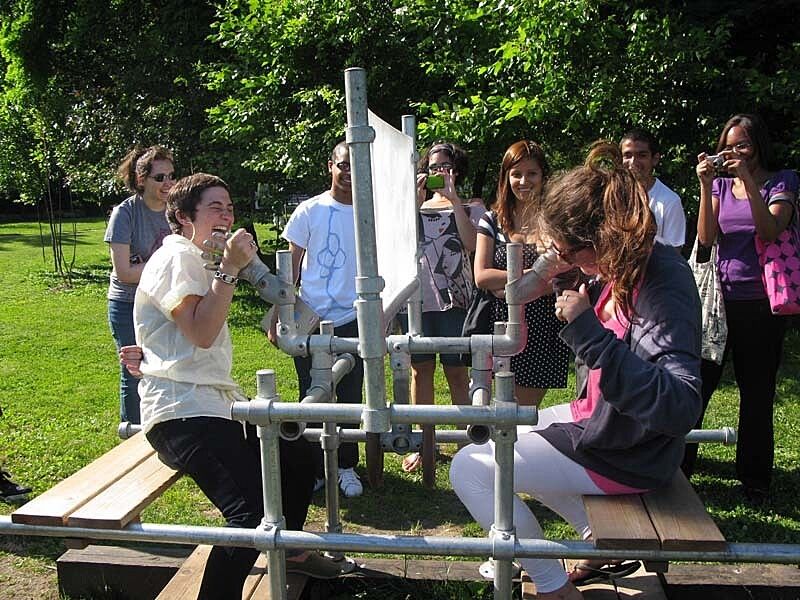 teens armwrestling with the aid of a sculpture