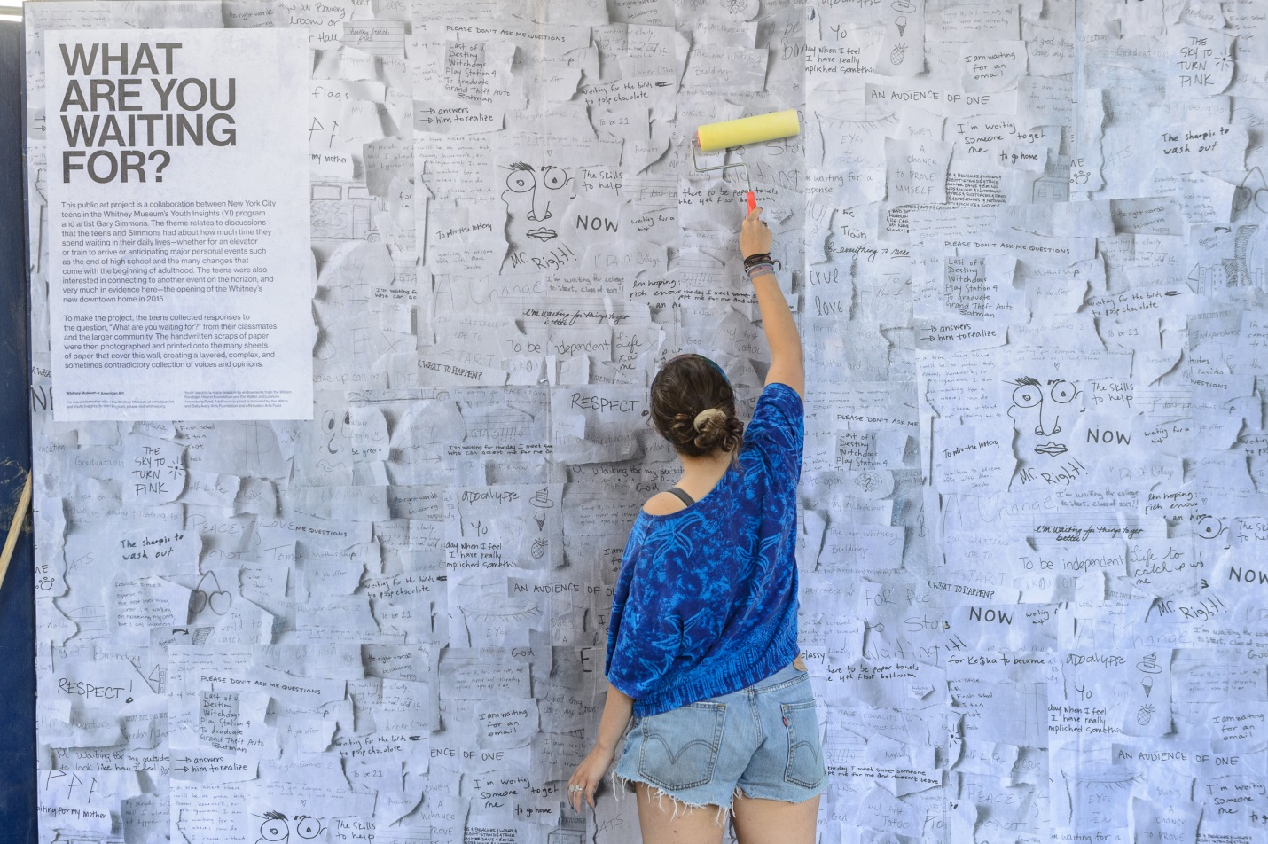 A teen putting up an outdoor poster