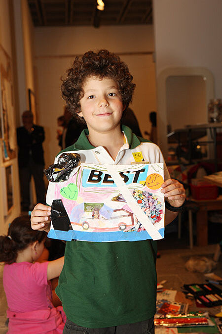 A child shows off their artwork