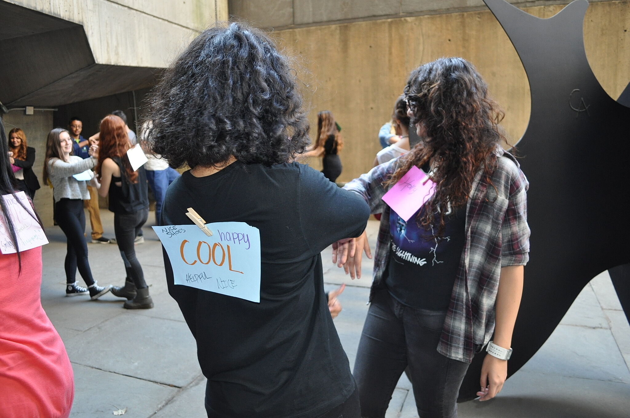 women with paper sign clipped to her back 