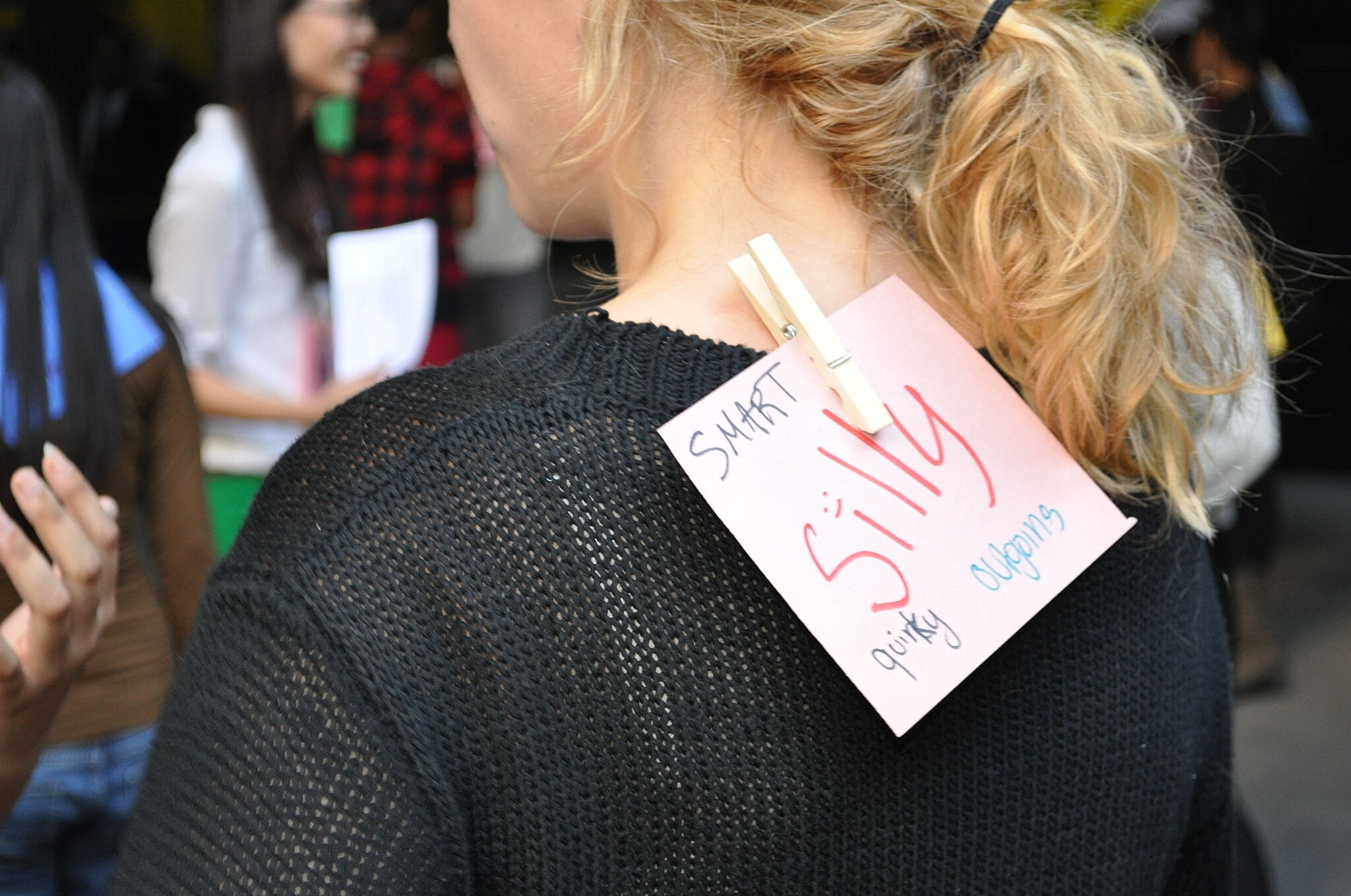 paper sign clipped to back of woman