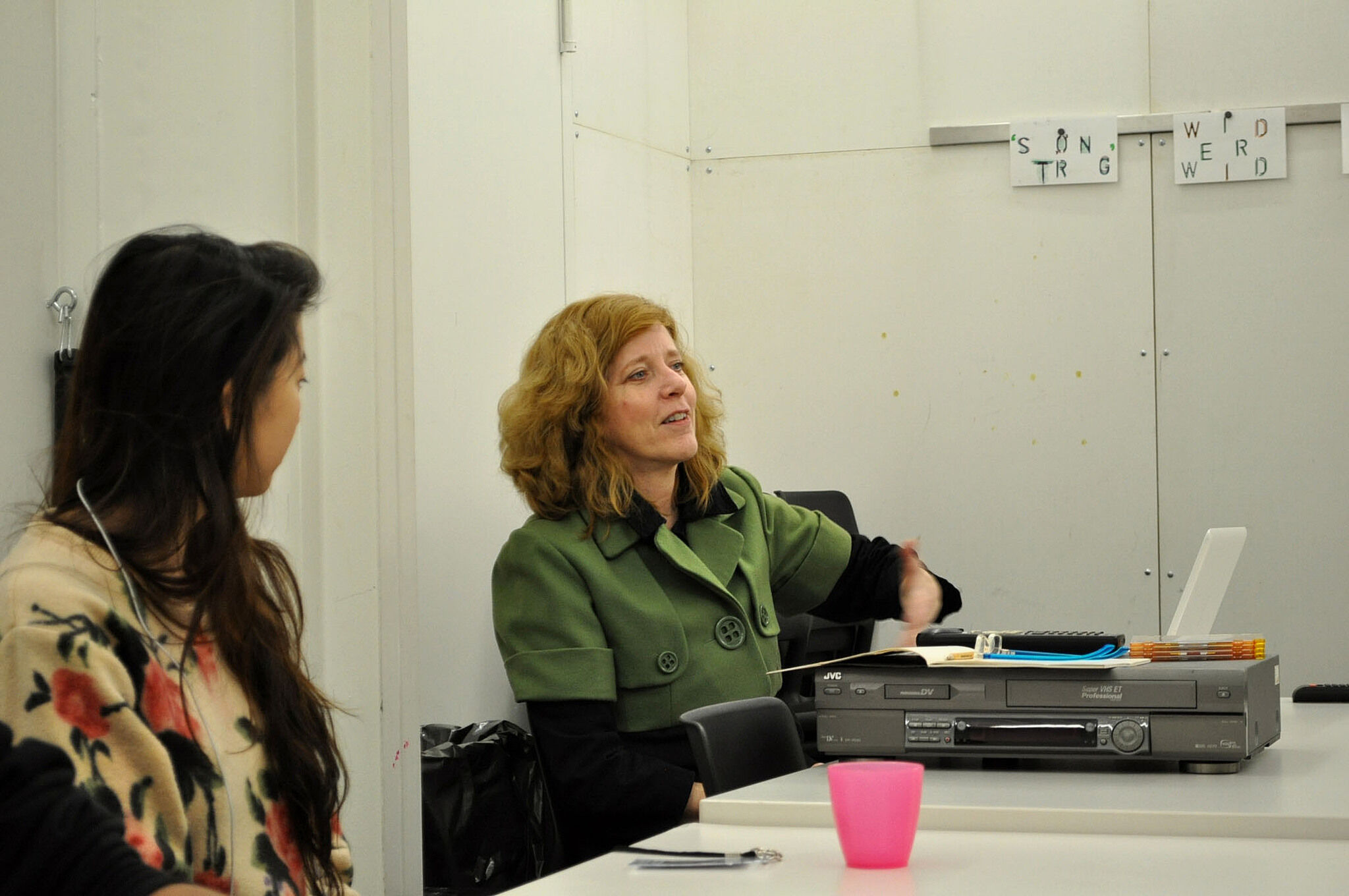 Artist talking to another student seated