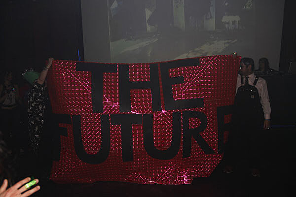 Sign saying "The Future" on it is hoisted.