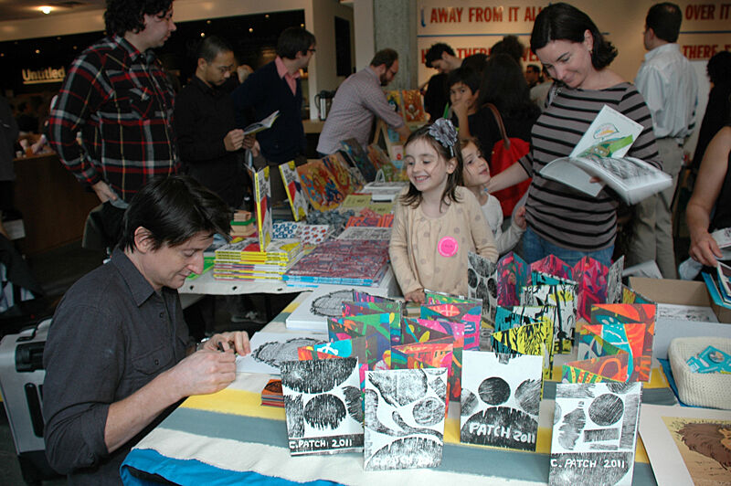 Families smiling in front of artist table.