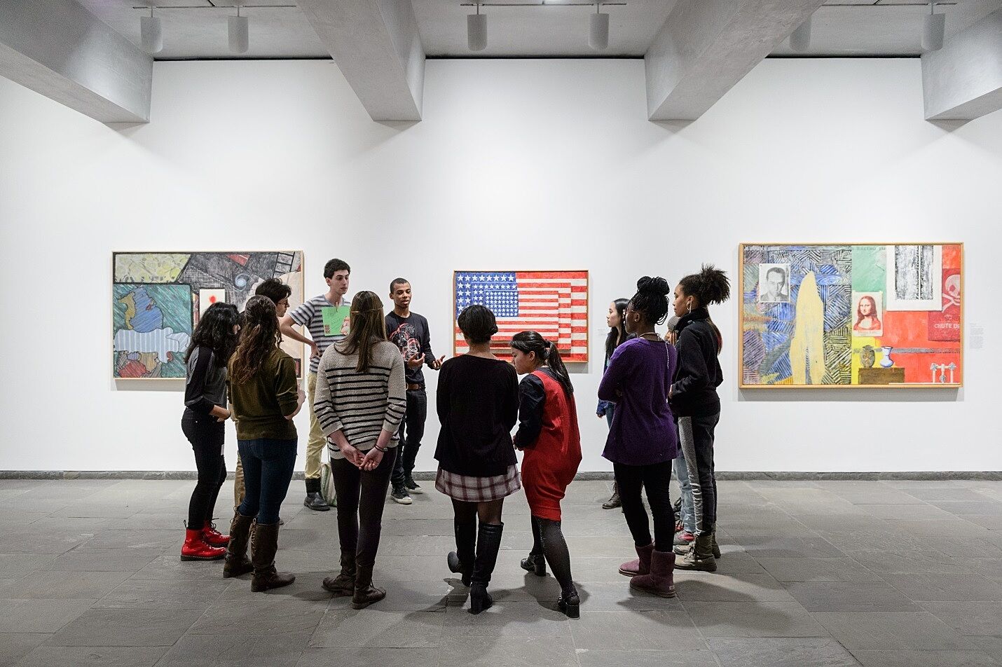 Students discuss artworks in exhibition.
