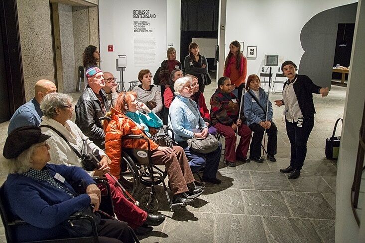 A tour group of partially sighted visitors listens to a Whitney guide