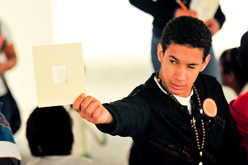 A student holds up a viewfinder