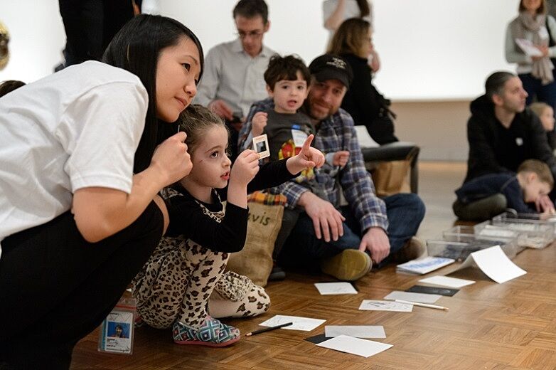 Kids, parents and Whitney staff work on a sketching activity in a gallery.