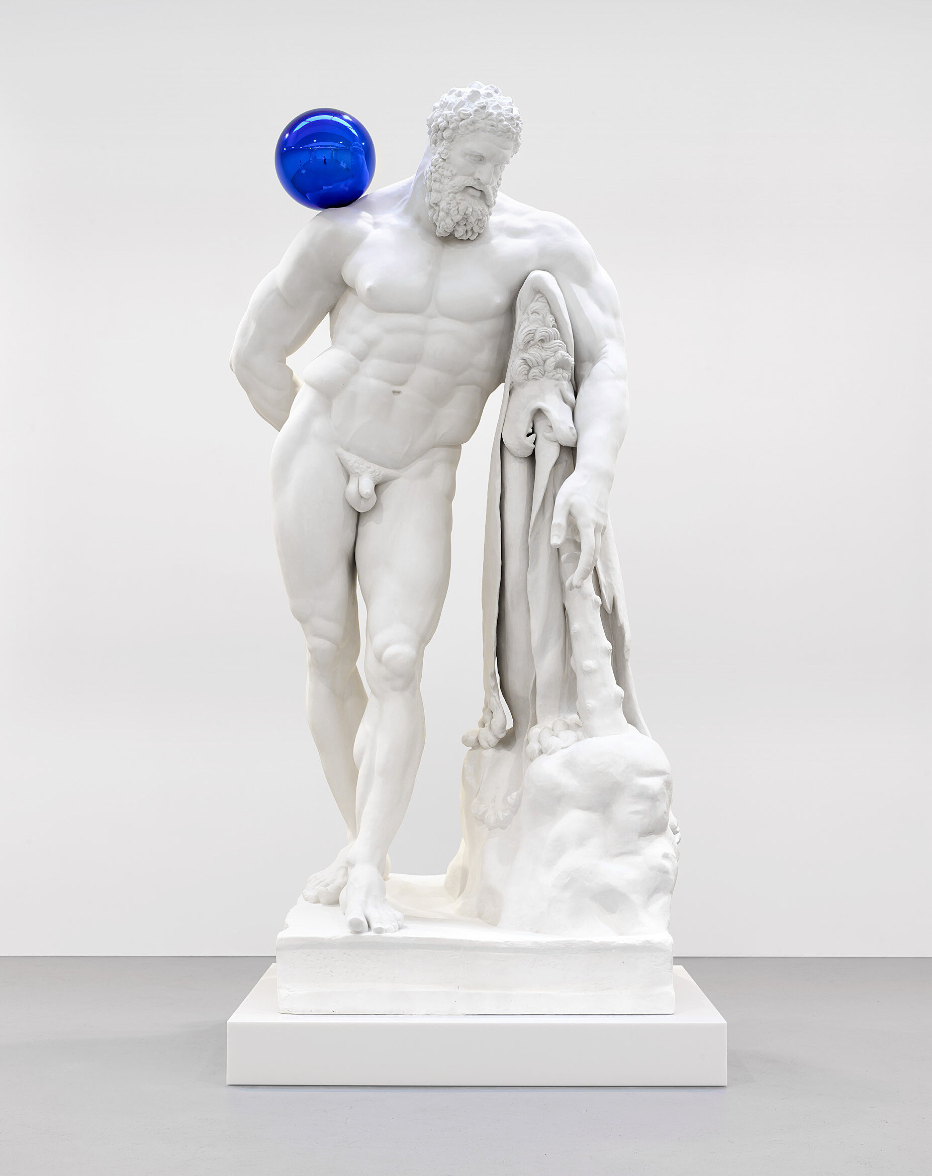 A sculpture of Hercules with a blue ball on his shoulder.