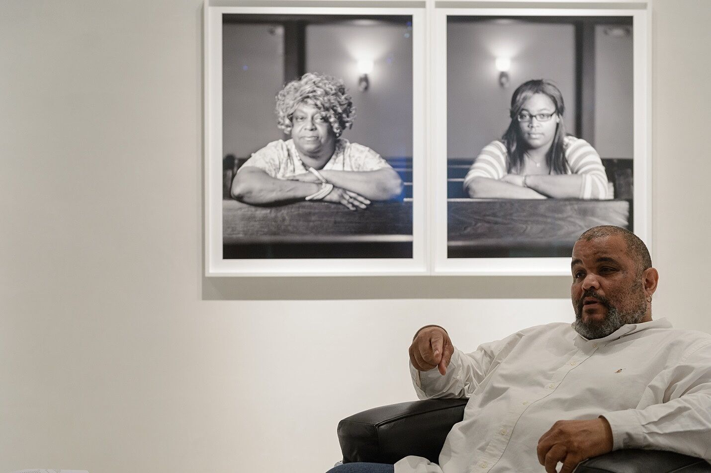 The photographer Dawoud Bey talks about his work in front of a black and white photo.