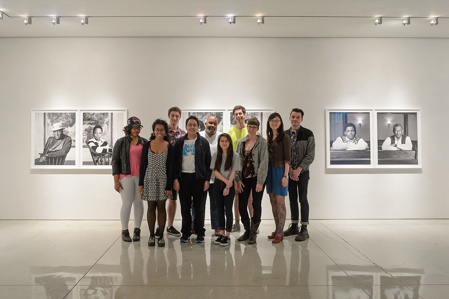 The artist Dawoud Bey poses with a group of youth leaders at his photo exhibit.