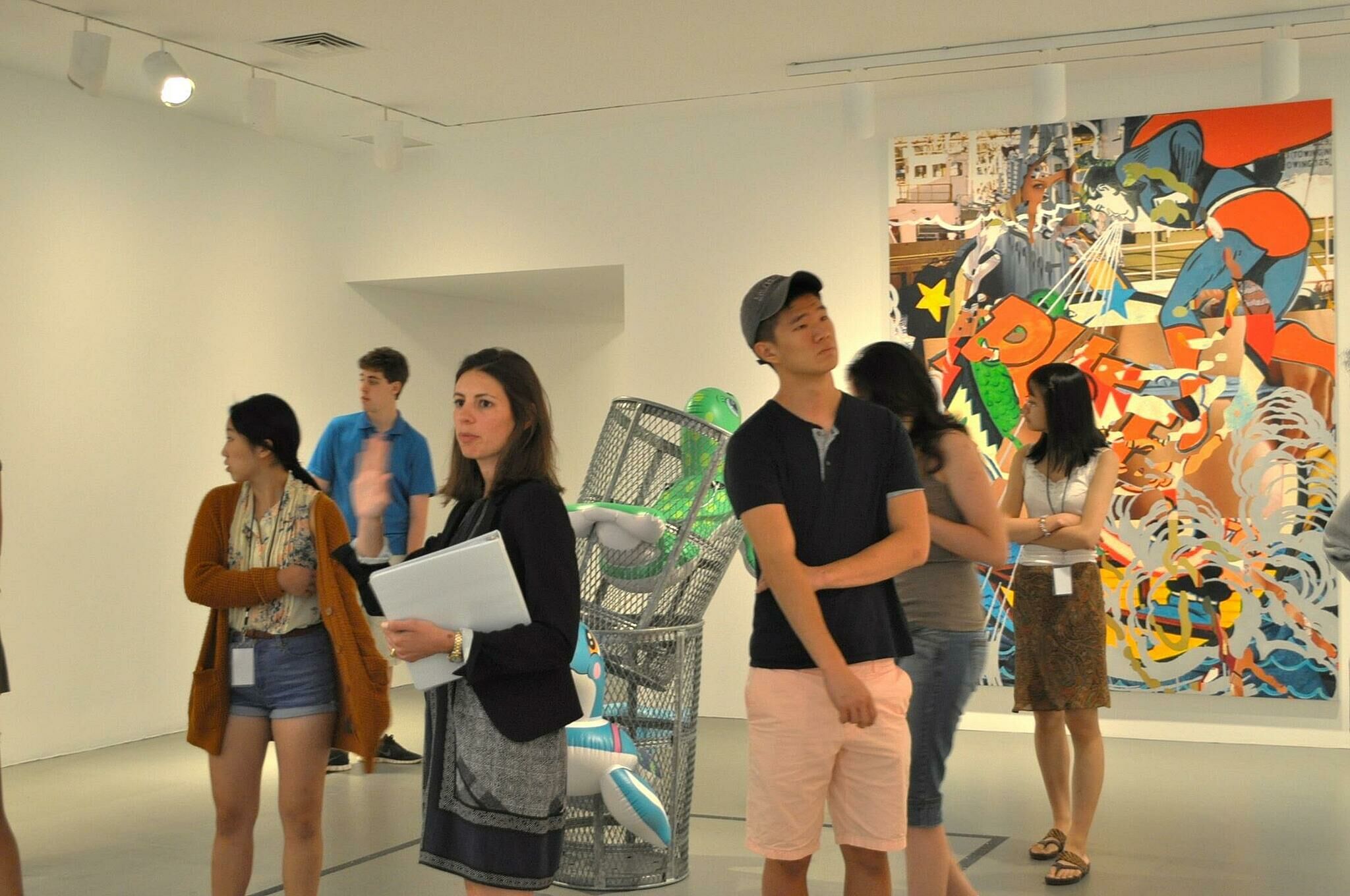 students stand in room with artwork
