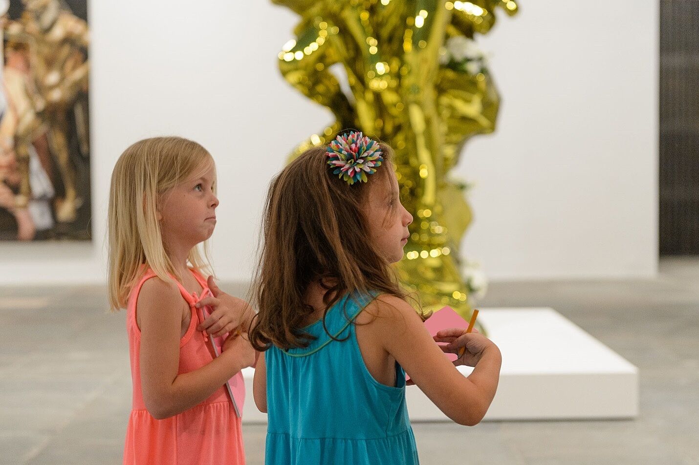 Two girls work on a project at the Jeff Koons exhibition